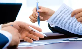 two people working on a paper contract together