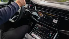 Interior of black car with persons hands on steering wheel.