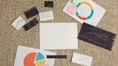 Various graphs and sheets of infographics laid out with handwritten post it notes.