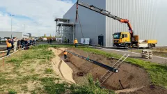 crane lowering a pipeline into the ground