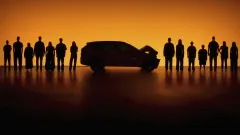 orange background behind a line of people with a crashed car in the middle