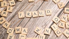 Scrabble letter tiles spelling fraud