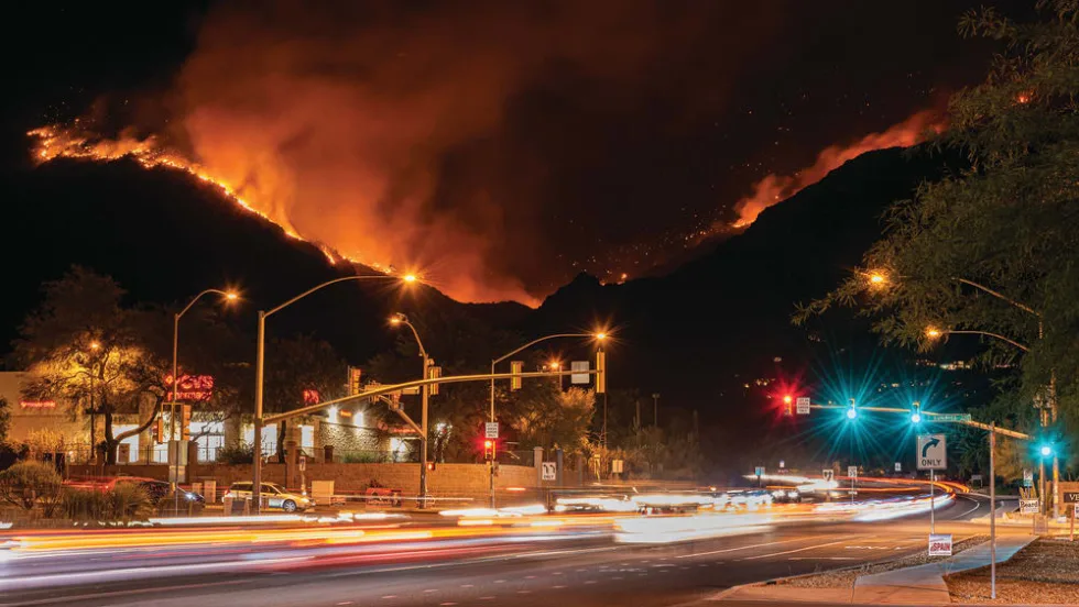 An empty street with a background of a wild fire mountain