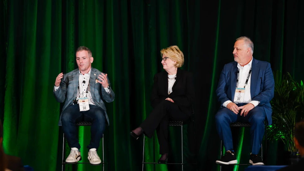 Photo of two men and one woman on a discussion panel
