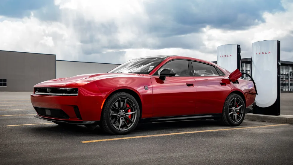 red battery-electric vehicle using a Tesla Supercharging station