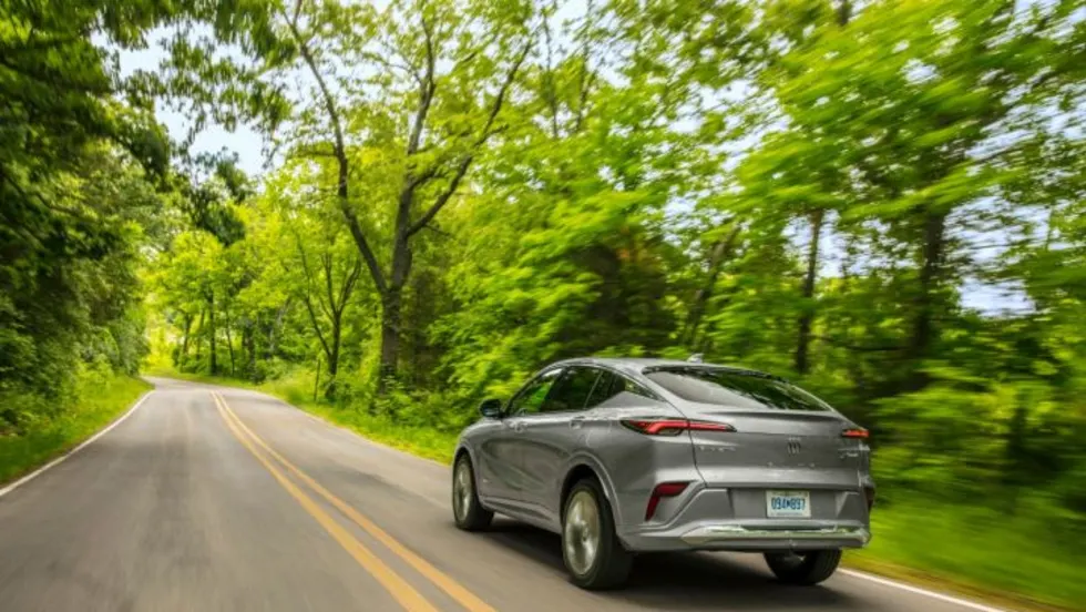 Photo of Buick Envista moving down road flanked by trees