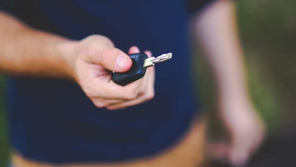 Photo of man holding a car key