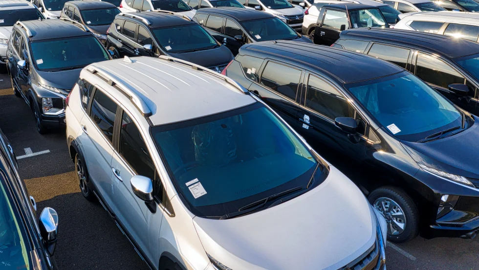 Photo of parked cars of various types for sale on a lot