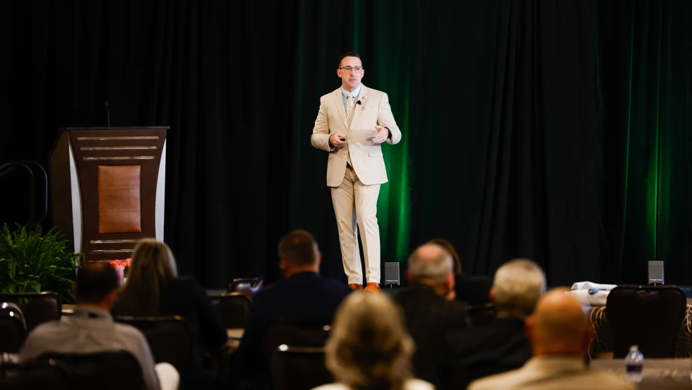 Dustin Gingerich standing on stage giving a presentation