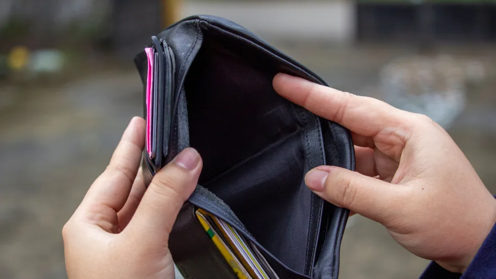 Woman's hands holding an wallet empty of cash