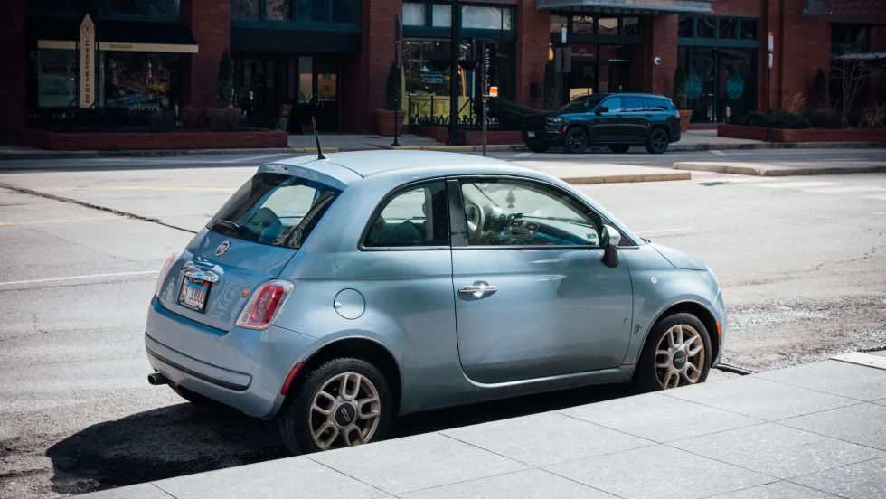 Light-blue Fiat car parked on a sunny Chicago street