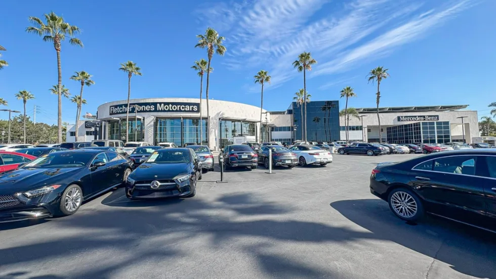 outside shot of Fletcher Jones Motorcars, white building with various cars out front
