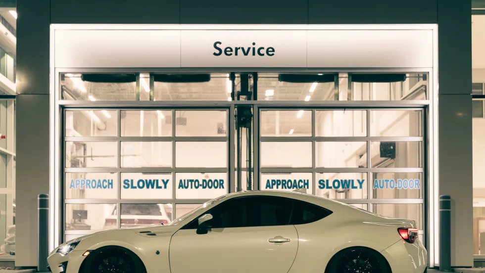 White backlit BRZ sitting in front of mechanic.