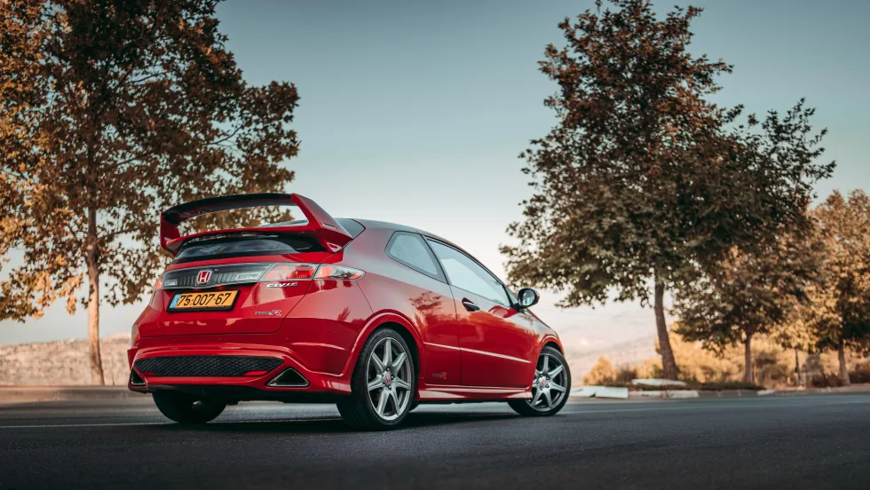 Red type R Honda civic parked on road.