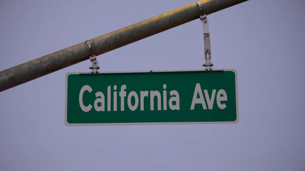 Green road sign that says California Ave