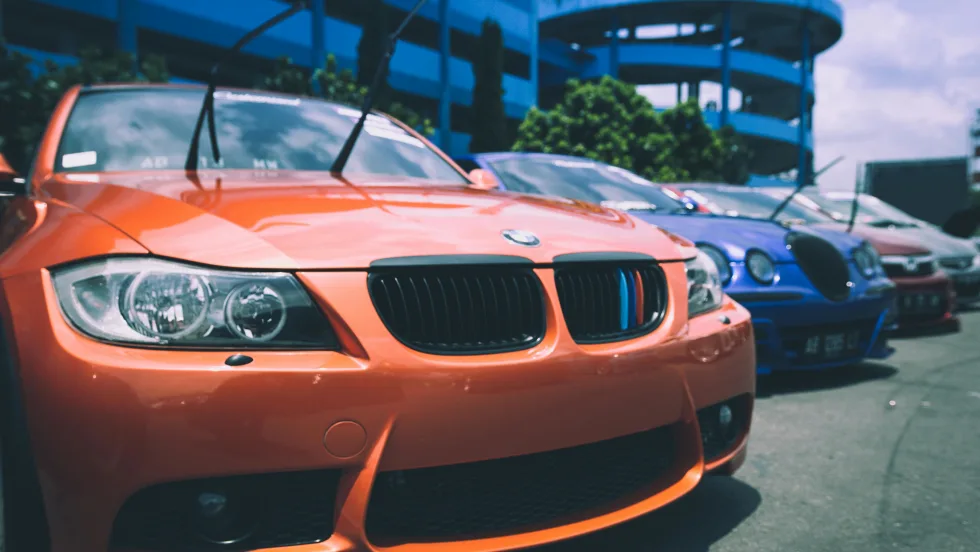 Orange BMW with windshield wipers sticking up.