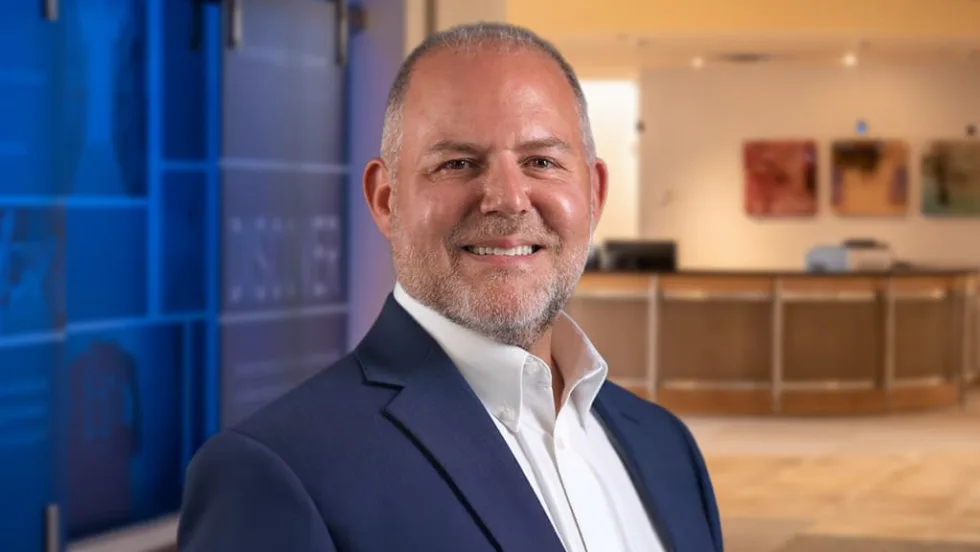 Man in blue suit smiling for photo.
