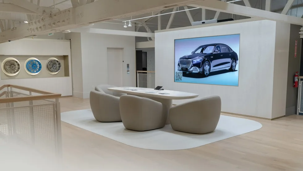 White meeting room in car dealership with rims displayed on wall and projected screen
