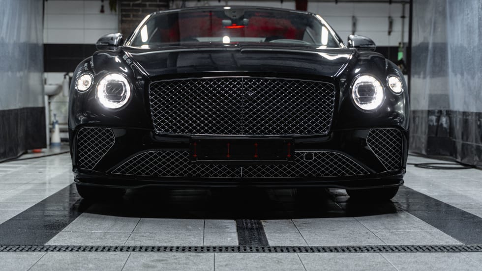 Front of black car with headlights on.