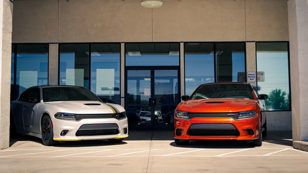 Two dodge cars outside of dealership.