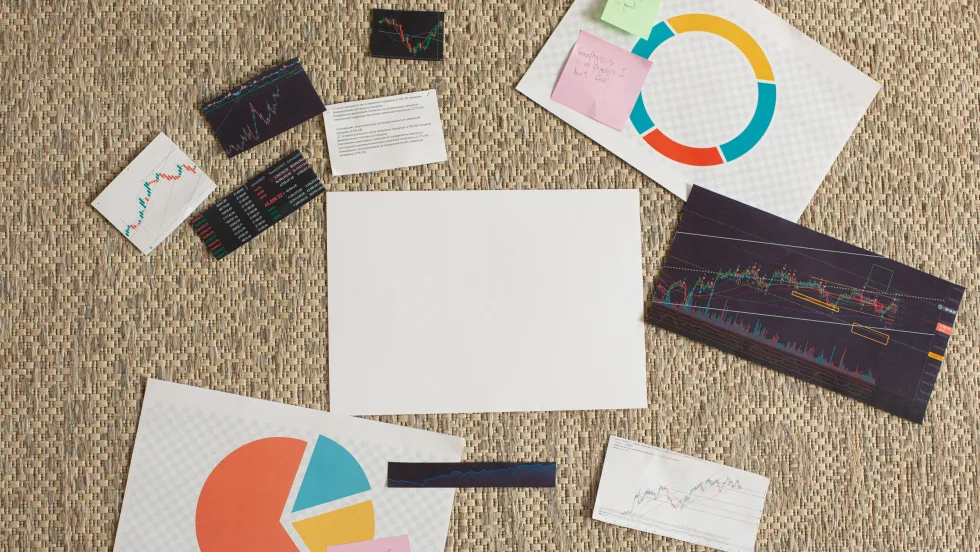 Various graphs and sheets of infographics laid out with handwritten post it notes.