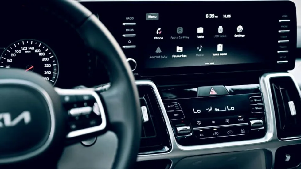 Phot of a dark Kia vehicle interior with steering part of steering wheel and dashboard