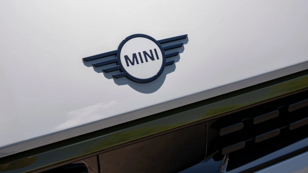 Photo of MINI nameplate on the hood of a white MINI Cooper