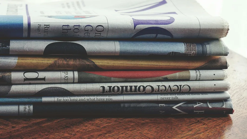 Photo of a stack of folded newspapers on a table