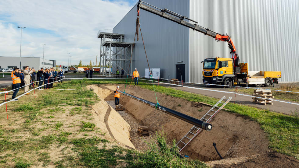 crane lowering a pipeline into the ground