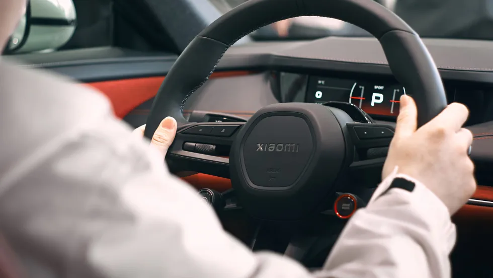 inside of car, person with hands on black steering wheel