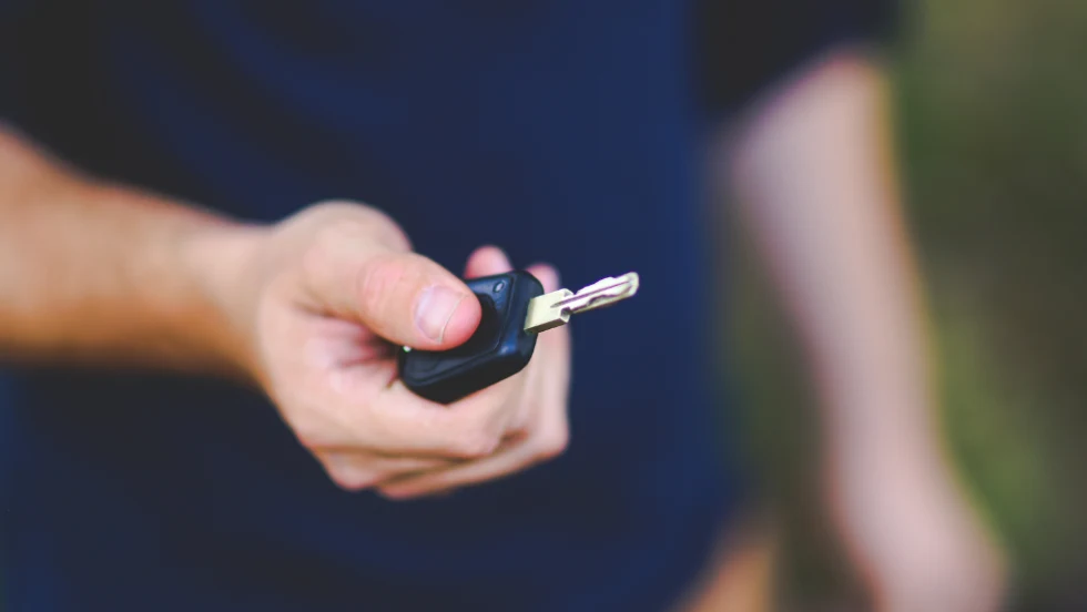man holding out car key