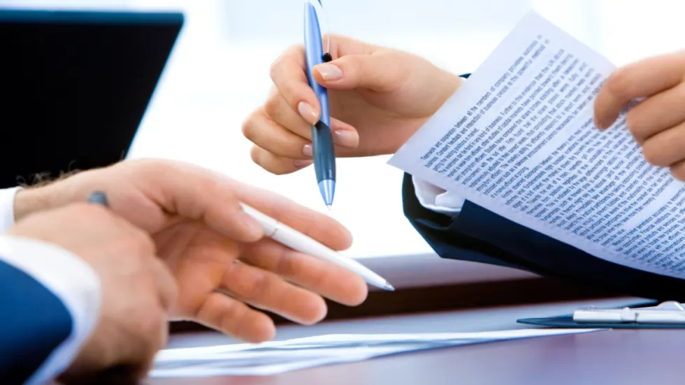 two people working on a paper contract together