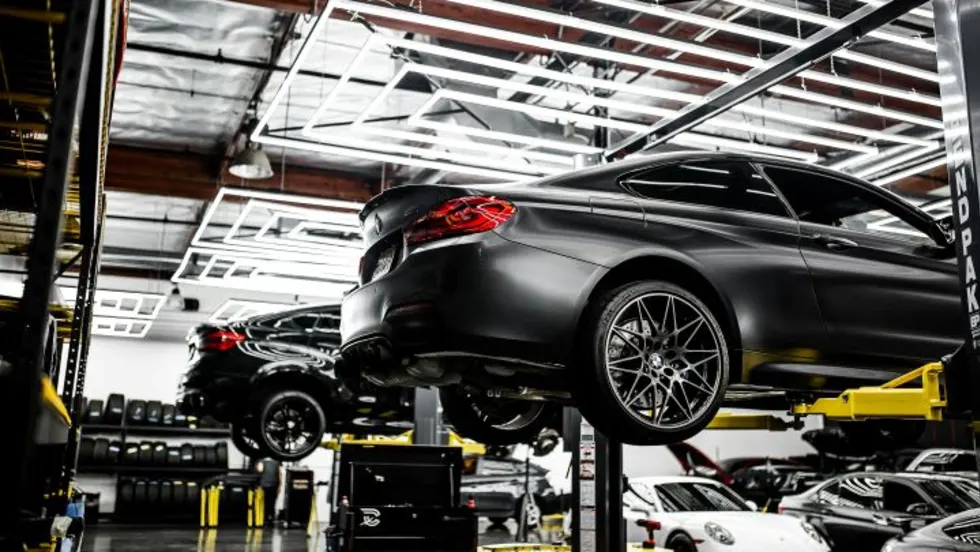 Photo of several cars on lifts in a service center