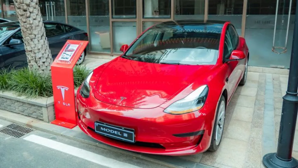 Photo of red Tesla car parked outside of building