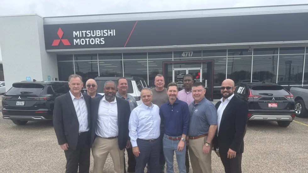 Photo of buyer and seller representatives in Waco Mitsubishi sale outside the dealership