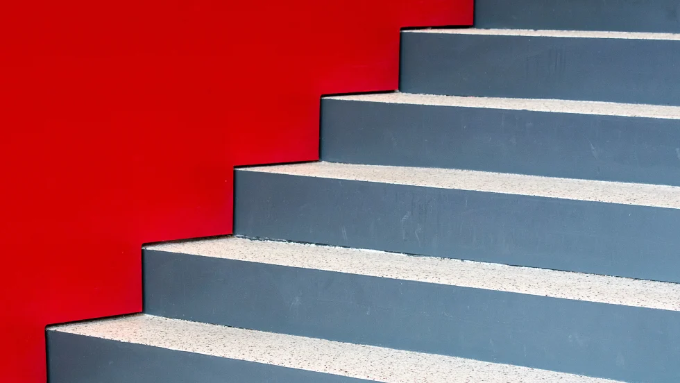 Staircase with no rails next to red-painted wall