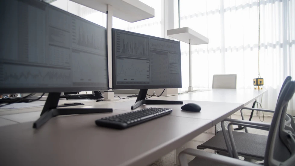 Two desktop computers side by side on otherwise empty office desk