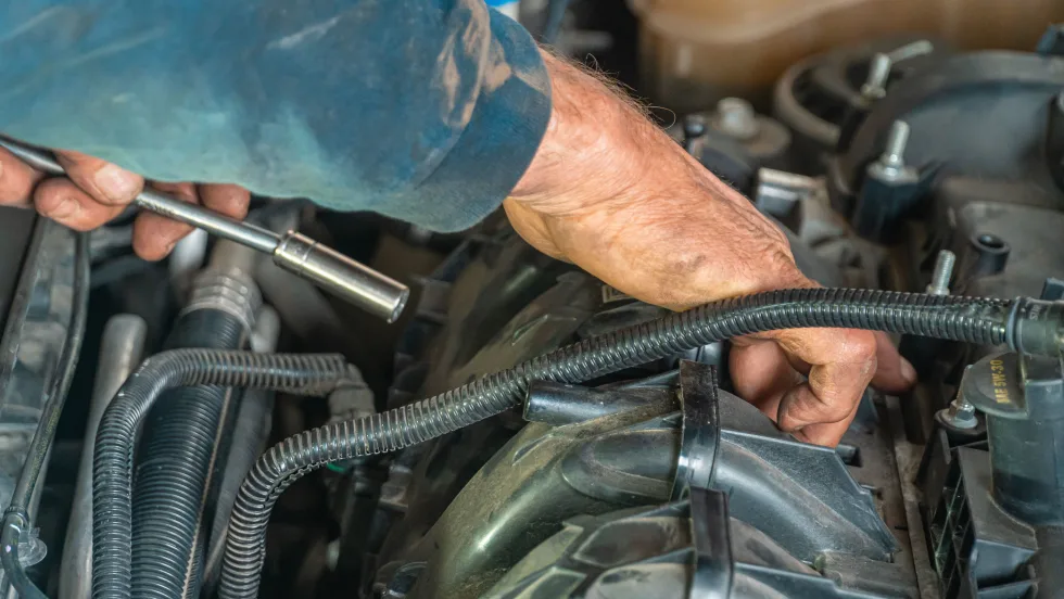Mechanic's hand working in car engine