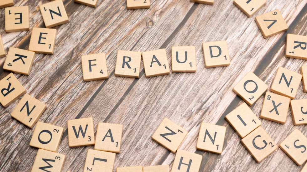 Scrabble letter tiles spelling fraud