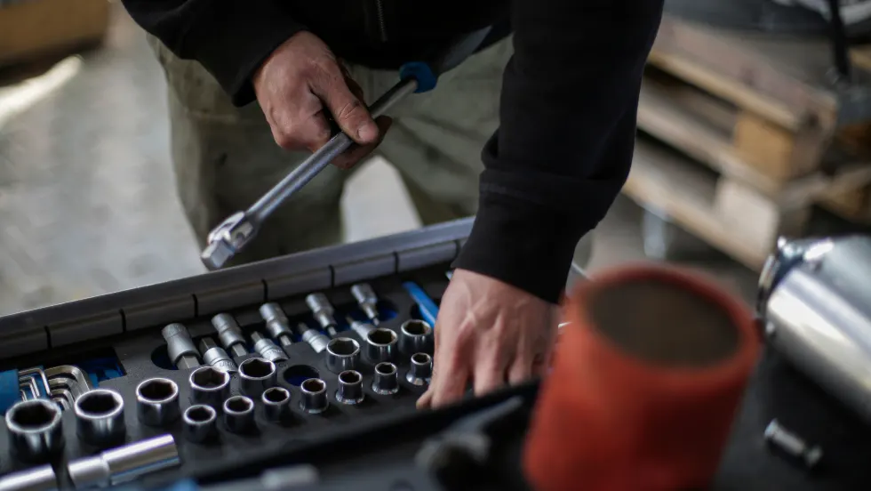 Mechanic's hand picking through a toolbox