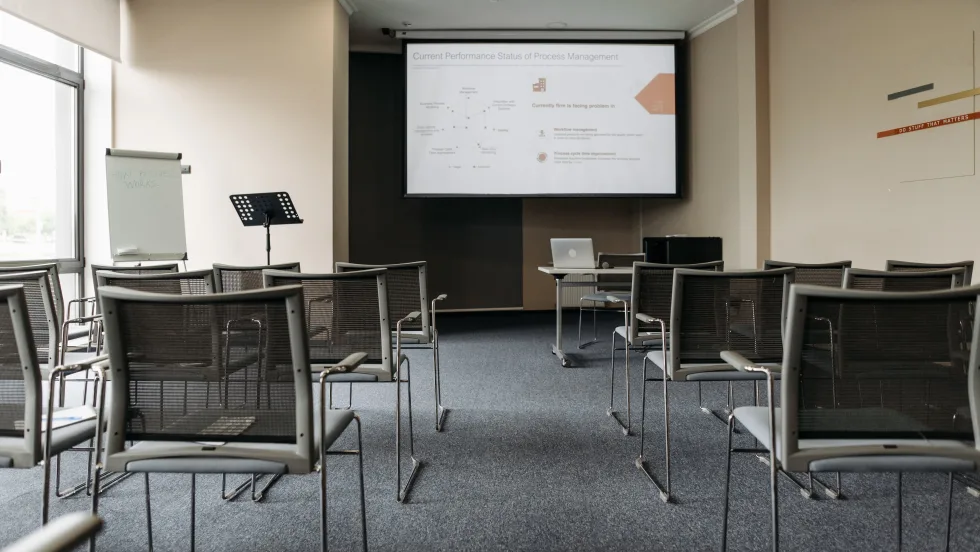 Empty classroom with lecturn, chairs and video proejction screen