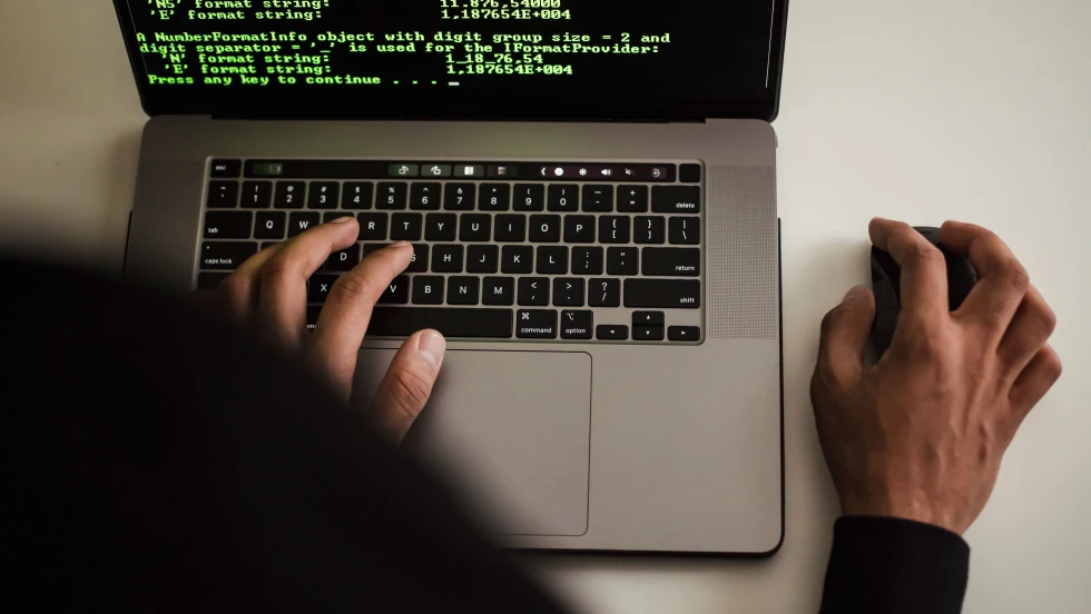 Person at laptop with green-colored code on the screen