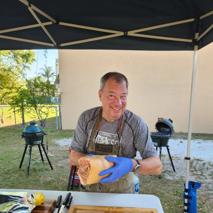 Photo of article author barbecuing meat under a shelter in a yard