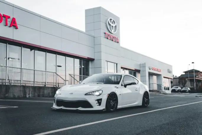 Photo of car parked in front of Toyota dealership