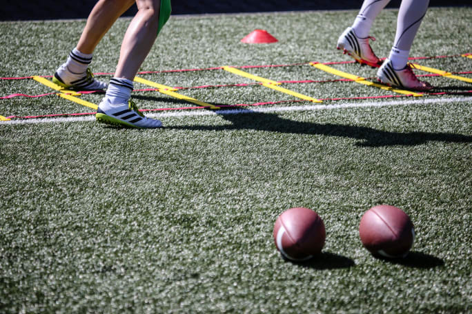 Photo of two football players' feet on the field during practice