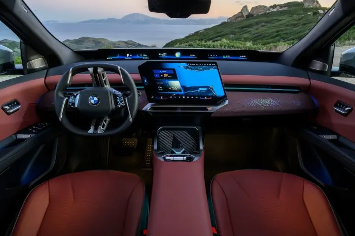 Photo of interior of BMW iX3 vehicle with landscape ahead framed by windshield