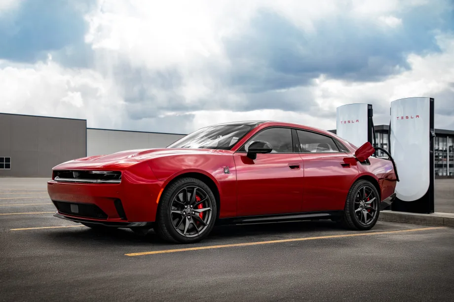 red battery-electric vehicle using a Tesla Supercharging station