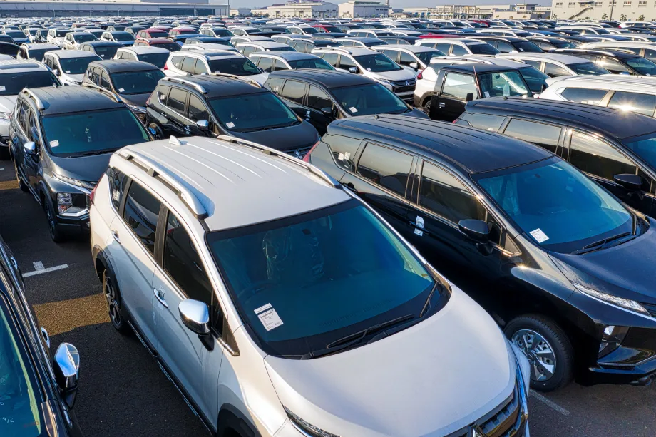 Photo of parked cars of various types for sale on a lot