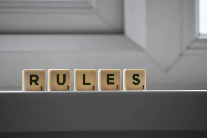 Photo of scrabble letters spelling 'RULE' sitting on a surface