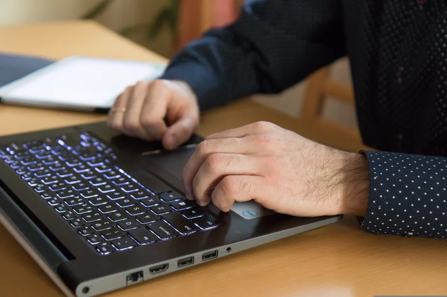 Photo of suited man's hands over a computer keyboard